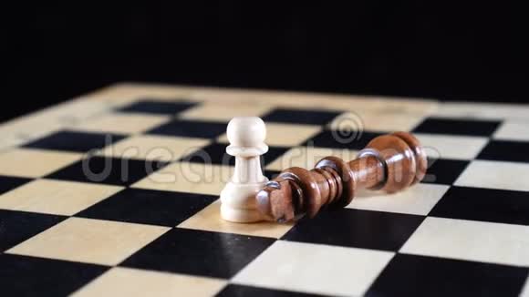 两个棋子和国王两边是被征服的黑色棋子白色棋子直立着视频的预览图