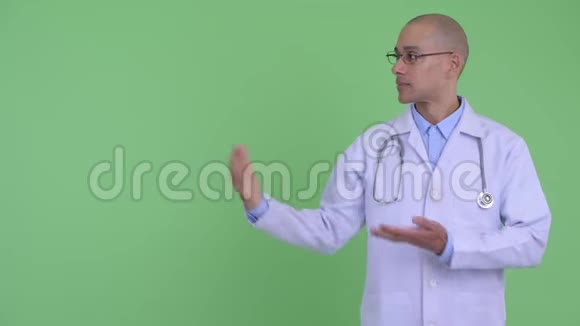快乐的秃头多民族医生展示了一些东西并竖起了大拇指视频的预览图
