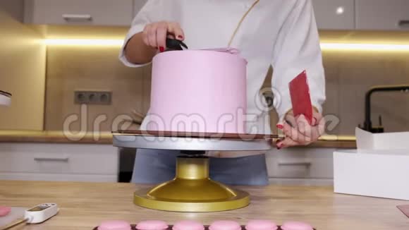 女面包师正在厨房里做一个美味的粉红色蛋糕视频的预览图