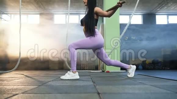英俊的年轻女子蹲在健身房训练时加强腿和臀部视频的预览图