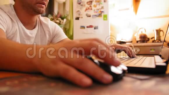 男人坐在家里的厨房桌子上男人用电脑看显示器屏幕近距离射击视频的预览图