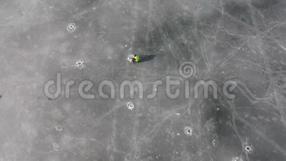 孤独的渔夫和湖冰上的许多冰洞空中视频的预览图