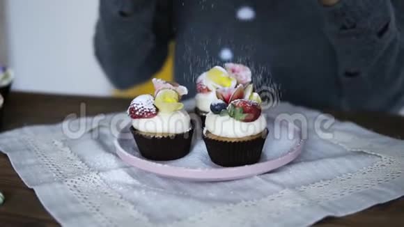 厨房里装饰着美味精美装饰的纸杯蛋糕带灰色的女人视频的预览图