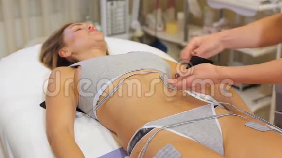 水疗中心的女人正在接受腹部皮肤的电刺激视频的预览图