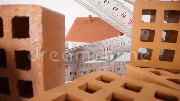慢速相机飞行通过微型砖块和测量折叠规则到模型房与门钥匙和建筑蓝图视频的预览图