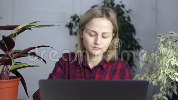 女孩画睫毛在笔记本电脑后面工作视频的预览图