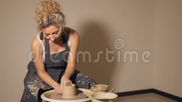 在陶工轮子上工作的女人双手用泥壶雕刻一个杯子视频的预览图