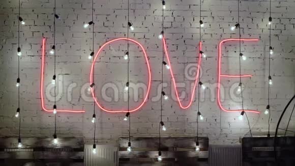 砖墙上串灯花环爱的词婚礼或浪漫的概念视频的预览图