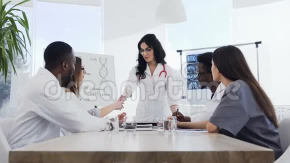 一位年轻的医务人员在医院的会议上做了有趣的讲座后向女医生鼓掌医院视频的预览图