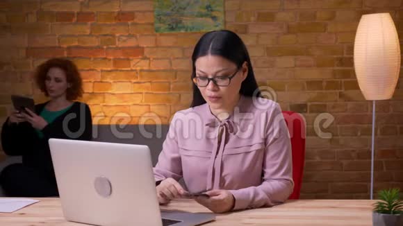 成人亚洲女商人在办公室室内笔记本电脑上网上购物的特写镜头女性雇员视频的预览图