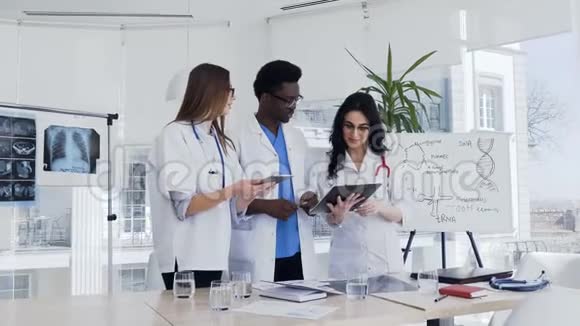 医疗队两名妇女和一名非洲男子站在医院讨论病人的诊断医疗小组视频的预览图