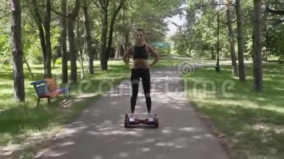 美丽的女孩有着运动的身体在公园的气垫板上行走视频的预览图