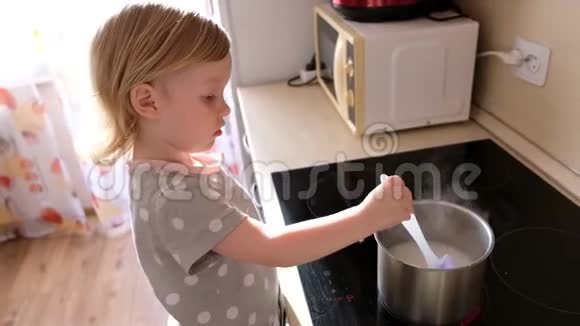 一个小可爱的女婴在厨房煮粥视频的预览图