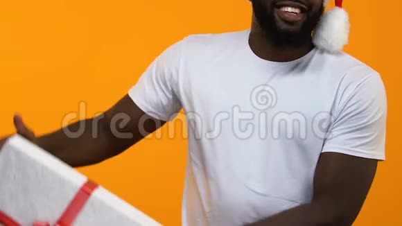 非洲青年男子白色t恤大礼盒圣诞大甩卖节日庆典视频的预览图