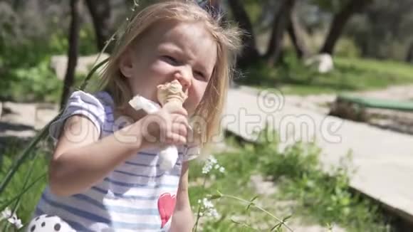 小女孩金发在热天吃华夫饼杯里的冰淇淋视频的预览图