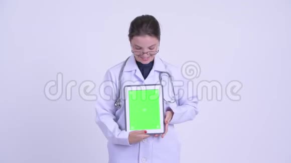 快乐年轻美丽的女医生在看数字平板电脑视频的预览图