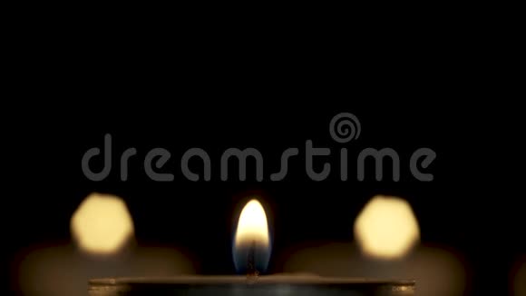 一支蜡烛的小火焰在黑暗中燃烧点燃两点光视频的预览图