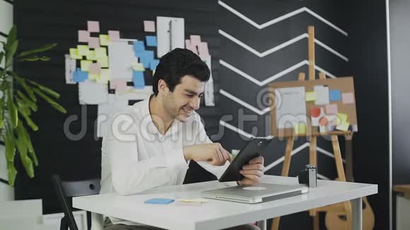 商人高兴地看着平板电脑笑着从他在屏幕上看到的东西视频的预览图