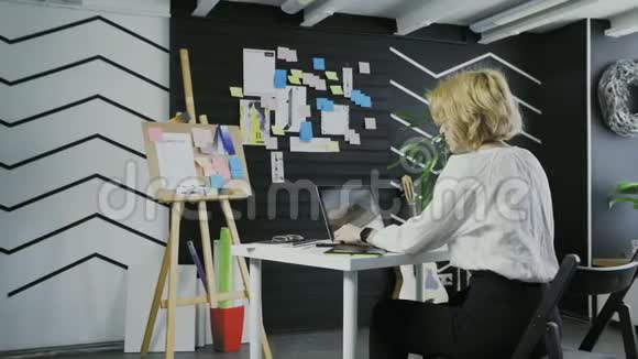 年轻女商人在办公室用电脑工作的背景视频的预览图