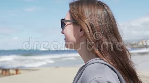 年轻的女人看着海洋戴着太阳镜的脸视频的预览图