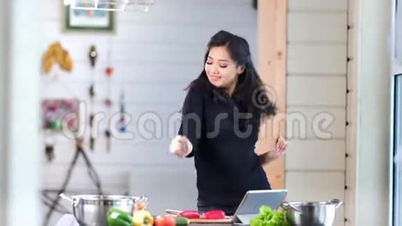 快乐的亚洲女人在烹饪新鲜的有机食物时在厨房里玩得很开心视频的预览图