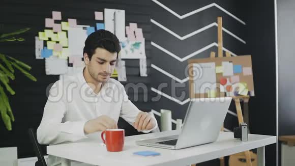 年轻的自由职业者穿着便装在办公室工作通过Skype和客户交谈视频的预览图