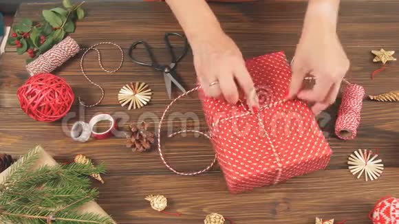 女人用木桌上的设备和装饰物品包装礼盒准备庆祝圣诞节视频的预览图