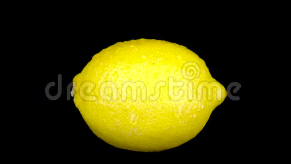 水喷在柠檬上在黑色的背景下视频的预览图