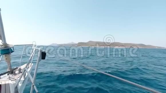 在阳光明媚的一天里一艘大型游艇通过深蓝色的海洋海峡驶向希腊岛视频的预览图