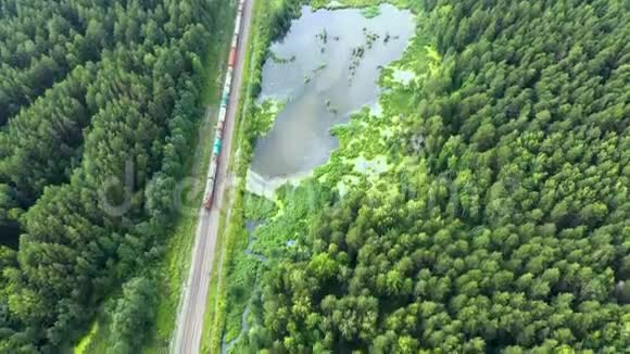 火车在树林里的乌拉尔沼泽湖用两面铁路运输煤电机车空中视频的预览图