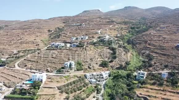 空中无人机飞往干燥的山区景观很少有房子位于山上在蒂诺斯希腊视频的预览图