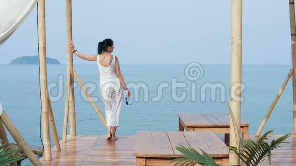 迷人的女人欣赏美丽的海景视频的预览图