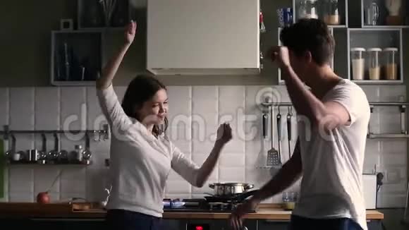快乐的青少年夫妇在厨房里跳舞开心视频的预览图
