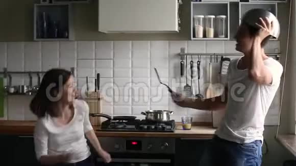 有趣的夫妇假装打架或厨房战争拿着餐具视频的预览图