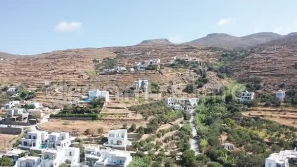 空中无人机飞往干燥的山区景观很少有房子位于山上在蒂诺斯希腊视频的预览图