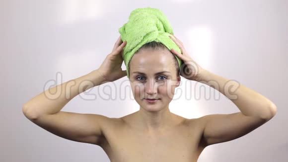 女孩从湿发中取出一条毛巾然后擦拭视频的预览图