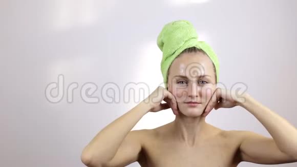 头上有毛巾的女孩做面部按摩视频的预览图