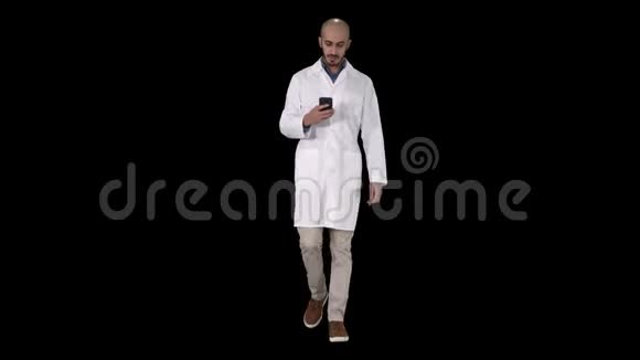 男阿拉伯医生走路时在电话上发短信阿尔法频道视频的预览图