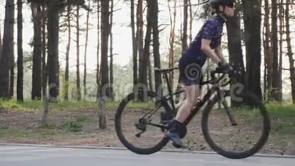 美丽的白种人自行车女孩开始骑她的道路自行车在公园穿蓝色球衣和黑色头盔道路自行车比赛视频的预览图