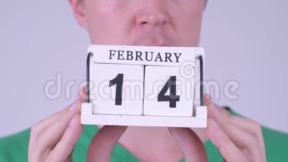 年轻人手里拿着日历块准备情人节视频的预览图