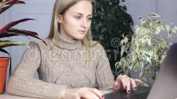 女孩正在他的笔记本电脑上打字里面有很多室内植物视频的预览图