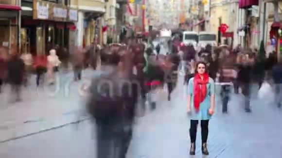 年轻女子摆姿势忙碌的街道人们四处走动4K视频的预览图