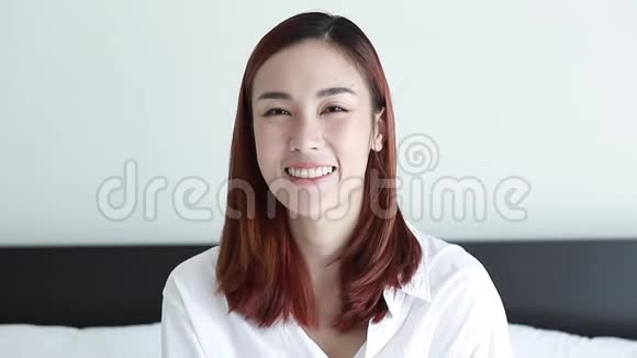 幸福的亚洲女人穿着白色衬衫在房间里笑的肖像视频的预览图