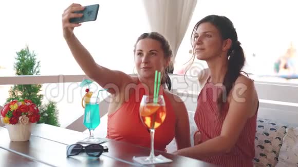 两个迷人的女朋友在夏天的周末在海滨的餐馆玩和自拍视频的预览图