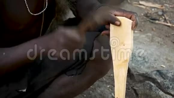 一个非洲部落的人从木器或工具棒中砍下刀子视频的预览图