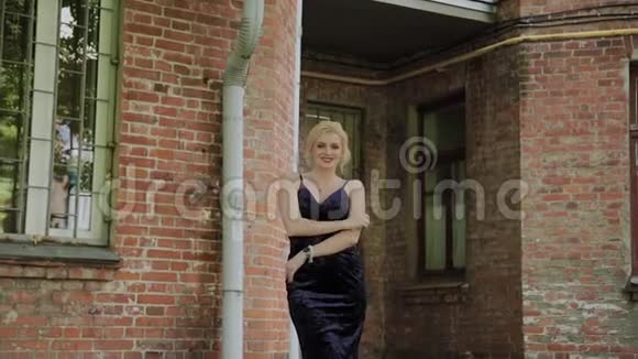 美丽的女人站在一个砖石老院里视频的预览图