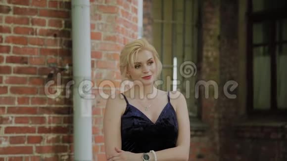 美丽的女人站在一个砖石老院里视频的预览图