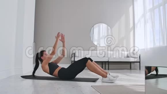 家庭健身理念女人在家里的地板上做腹肌复制空间视频的预览图