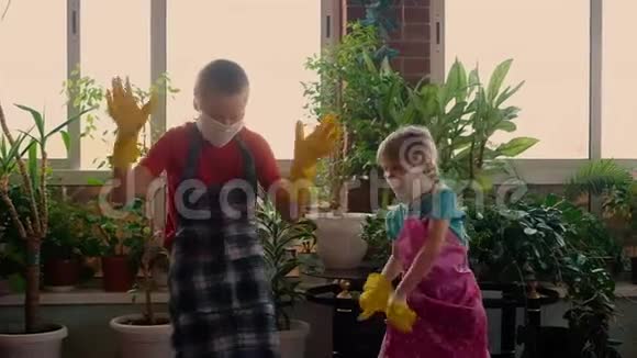 小可爱的女孩和男孩戴着防护面具和防护橡胶手套跳舞冠状病毒视频的预览图