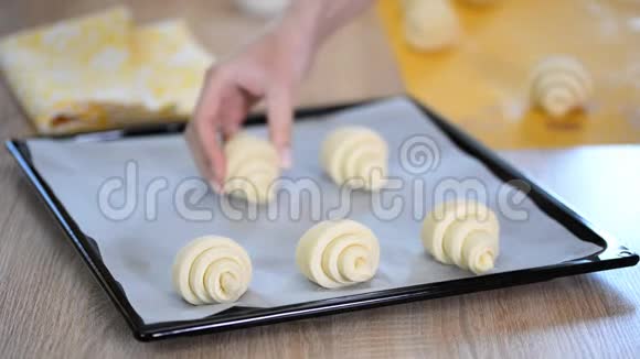 女厨师在厨房把牛角面包放在烹饪托盘上在一家面包店里做食物视频的预览图
